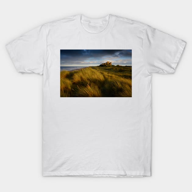 Bamburgh Castle at sunset T-Shirt by chrisdrabble